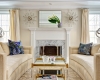 Carrara Fireplace surround, beige sofas, facing sofas, two coffee tables, symmetry, asymmetry, silk drapes